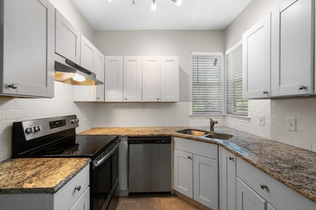 kitchen featuring under cabinet range hood, tasteful backsplash, appliances with stainless steel finishes, and a sink