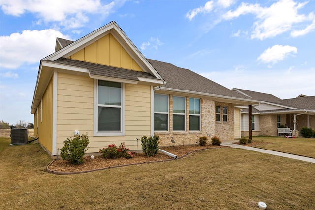 view of front of home with central air condition unit and a front lawn