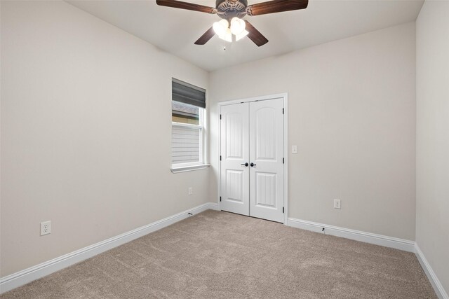 carpeted spare room with ceiling fan