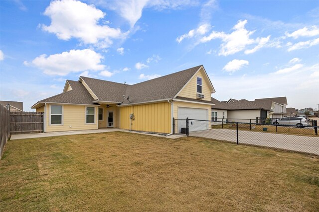 back of house with a lawn and a garage