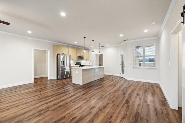 kitchen with dark wood-type flooring, crown molding, an island with sink, pendant lighting, and appliances with stainless steel finishes