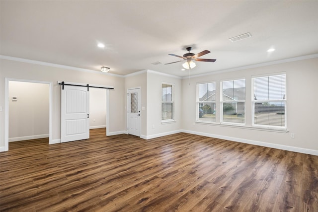 unfurnished living room with a barn door, ceiling fan, dark hardwood / wood-style flooring, and ornamental molding