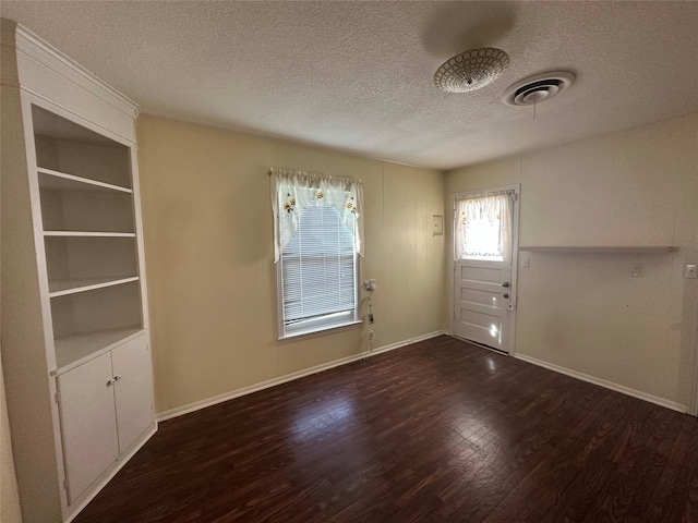 interior space featuring plenty of natural light, a textured ceiling, and dark hardwood / wood-style flooring