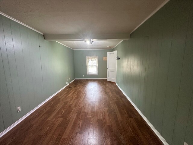 empty room with dark hardwood / wood-style flooring, ornamental molding, and wood walls