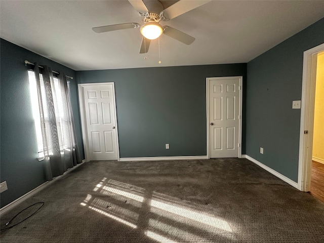 unfurnished bedroom featuring dark carpet and ceiling fan