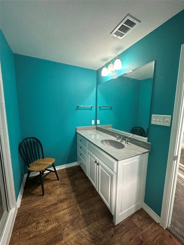 bathroom featuring hardwood / wood-style flooring, vanity, a textured ceiling, and a chandelier