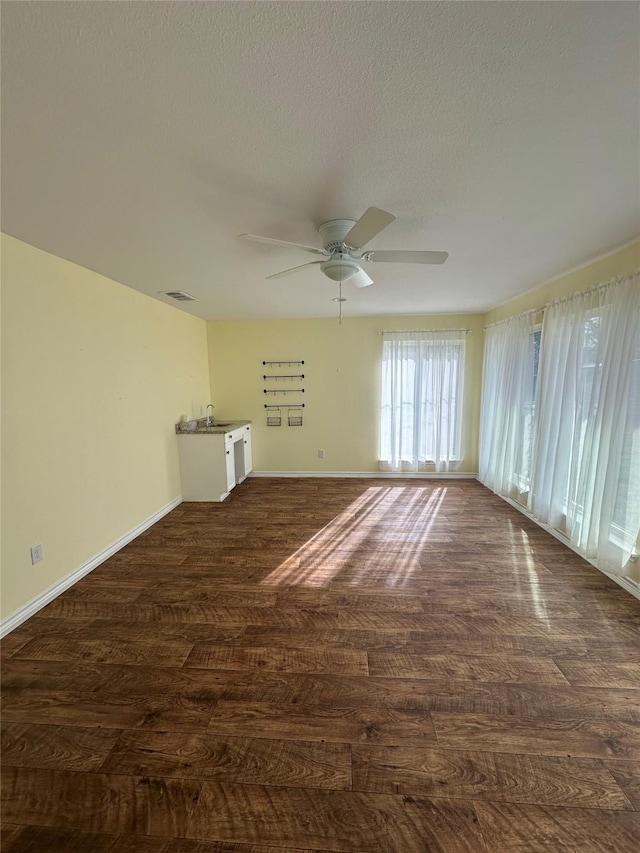 spare room with ceiling fan, dark hardwood / wood-style flooring, sink, and a textured ceiling