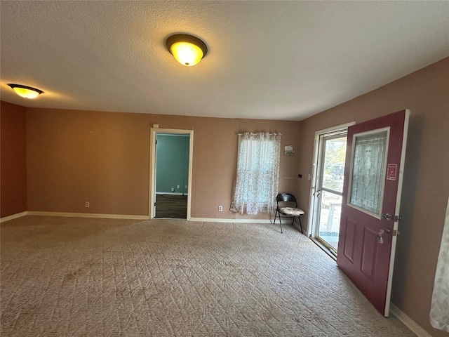 carpeted entryway with a textured ceiling