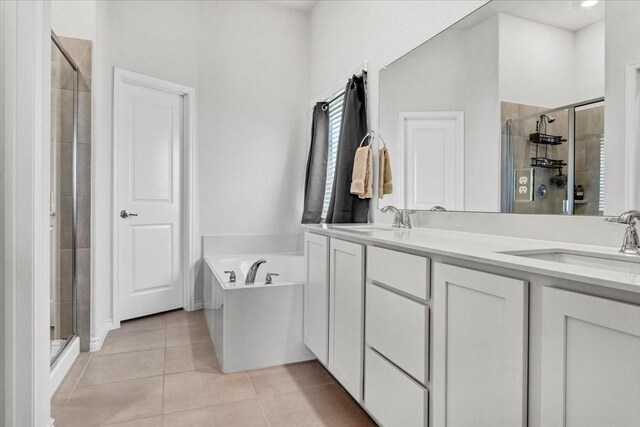 bathroom featuring tile patterned flooring, vanity, and shower with separate bathtub