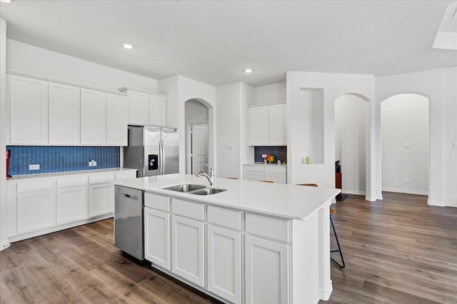 kitchen featuring sink, stainless steel appliances, a center island with sink, white cabinets, and hardwood / wood-style flooring