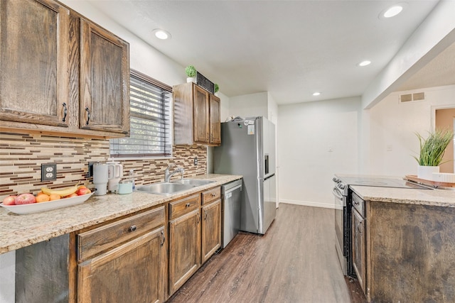 kitchen featuring decorative backsplash, sink, appliances with stainless steel finishes, and dark wood-type flooring