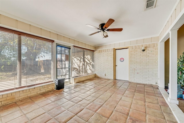 unfurnished sunroom featuring ceiling fan