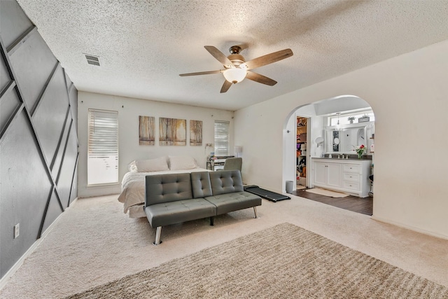 bedroom with multiple windows, ceiling fan, and a textured ceiling