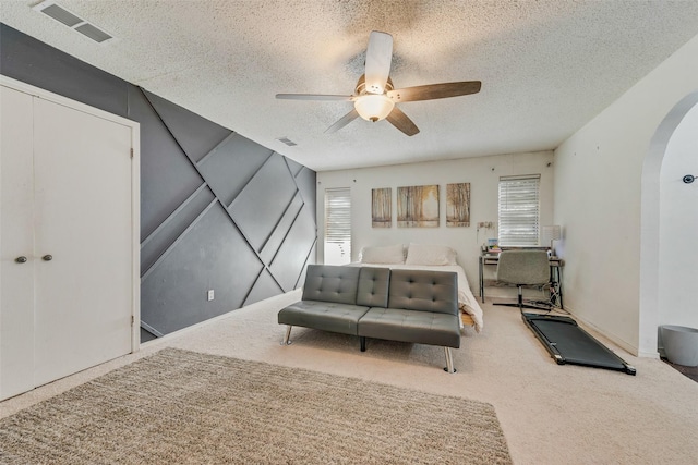 interior space featuring ceiling fan, carpet floors, and a textured ceiling