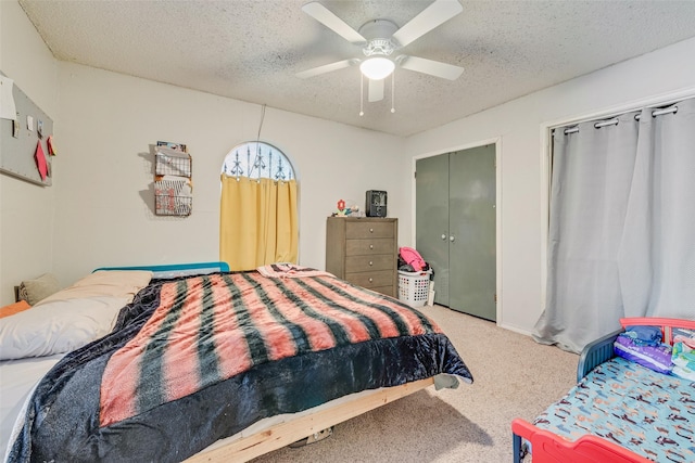 bedroom with ceiling fan, carpet, and a textured ceiling