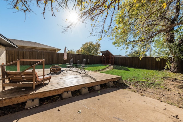 wooden deck with a yard and an outdoor fire pit