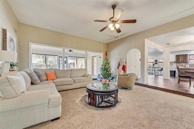 living room featuring ceiling fan, a textured ceiling, and hardwood / wood-style flooring