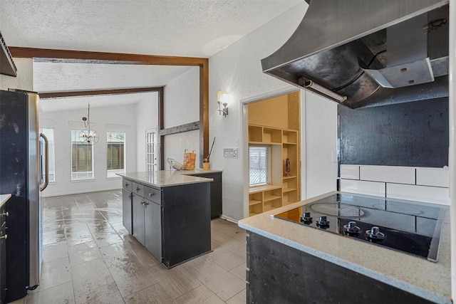 kitchen with vaulted ceiling with beams, a center island, a textured ceiling, and exhaust hood