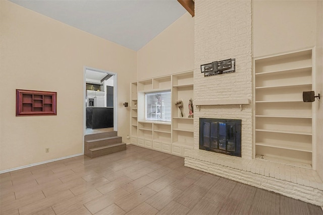 unfurnished living room featuring a stone fireplace, hardwood / wood-style floors, high vaulted ceiling, and built in shelves