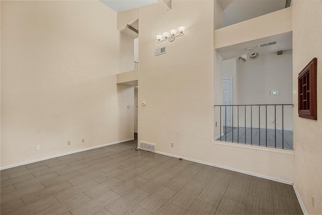 unfurnished room with a high ceiling and light wood-type flooring