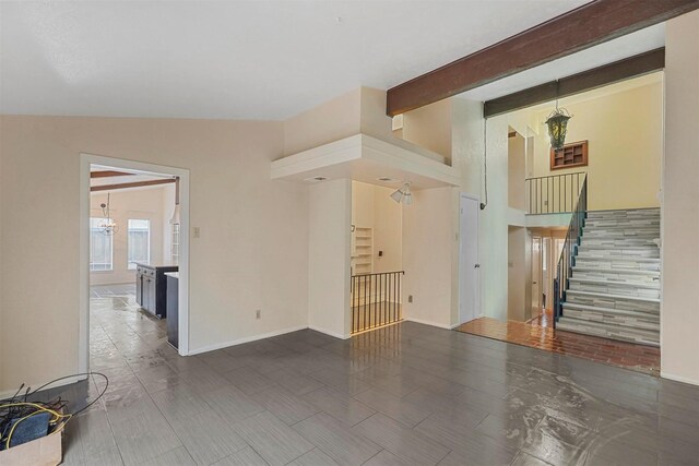 unfurnished living room with lofted ceiling with beams