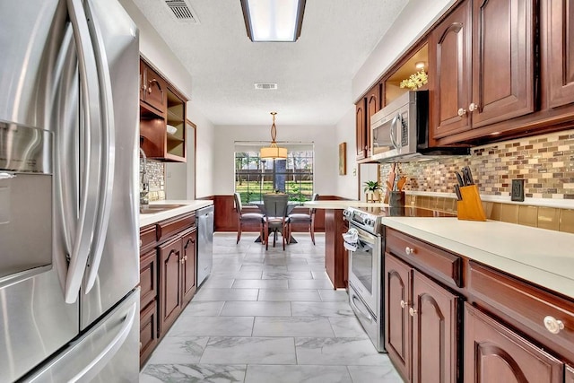 kitchen featuring decorative backsplash, decorative light fixtures, and stainless steel appliances