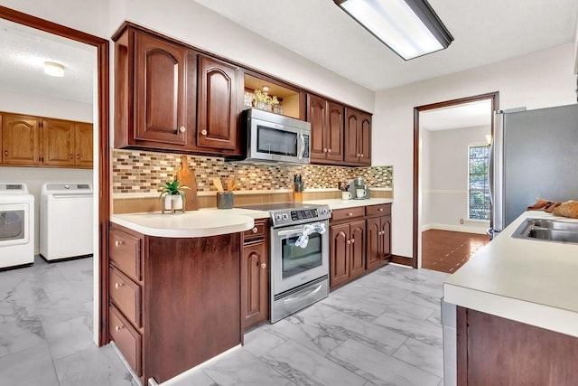 kitchen featuring separate washer and dryer, decorative backsplash, and appliances with stainless steel finishes