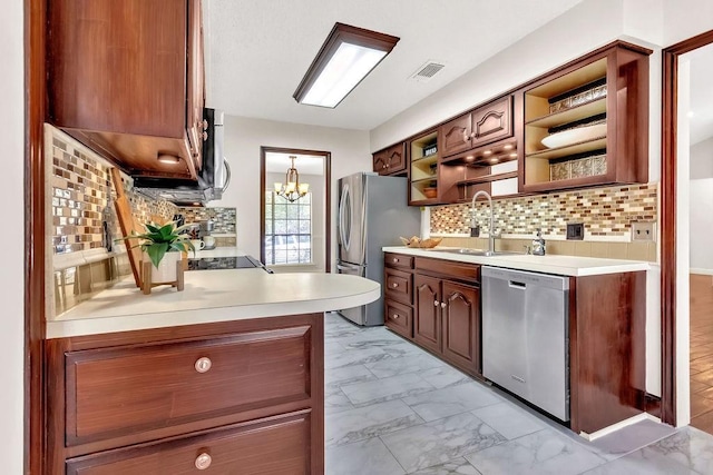 kitchen with decorative backsplash, stainless steel appliances, an inviting chandelier, and sink