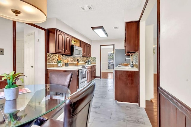 kitchen with decorative backsplash and stainless steel appliances