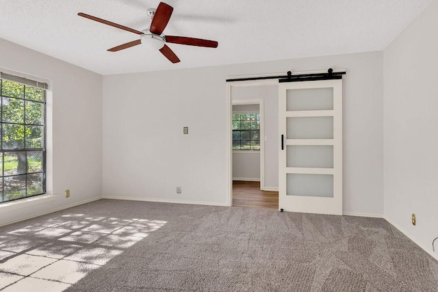 carpeted spare room featuring ceiling fan, built in features, and a textured ceiling