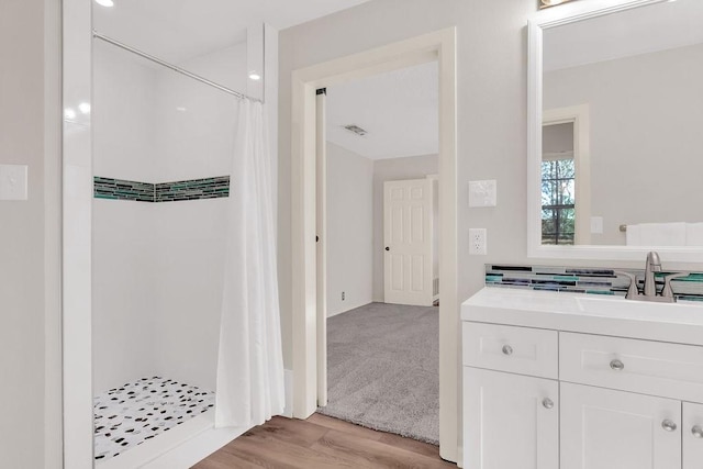 bathroom with hardwood / wood-style flooring, vanity, and curtained shower