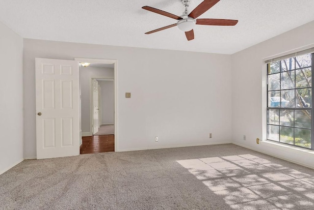 empty room featuring light carpet, ceiling fan, and a textured ceiling