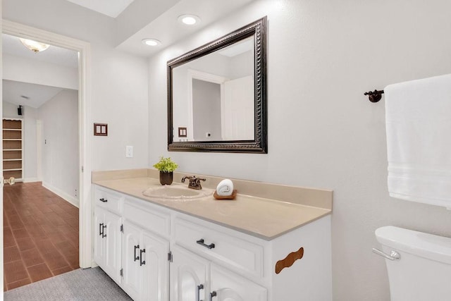 bathroom featuring wood-type flooring, vanity, and toilet