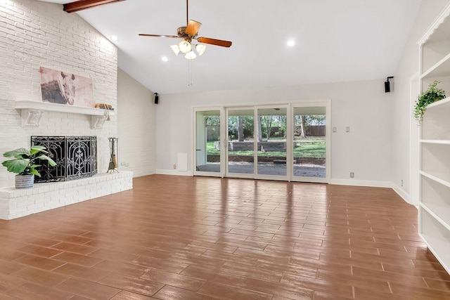 unfurnished living room with ceiling fan, beamed ceiling, high vaulted ceiling, a fireplace, and hardwood / wood-style flooring