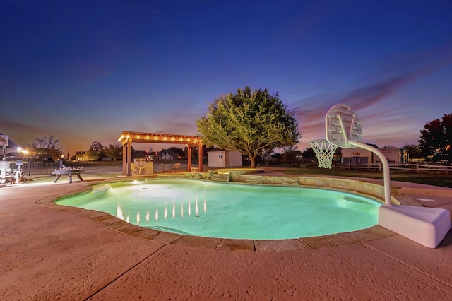 pool at dusk with a storage unit and a patio