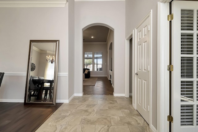 hallway with a chandelier, light hardwood / wood-style flooring, and crown molding