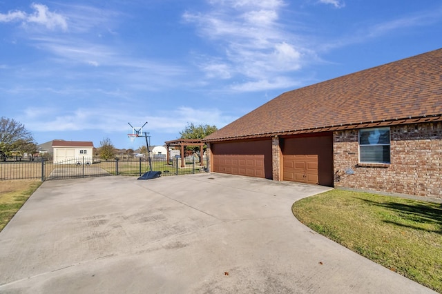 view of home's exterior featuring brick siding, a yard, roof with shingles, fence, and a garage