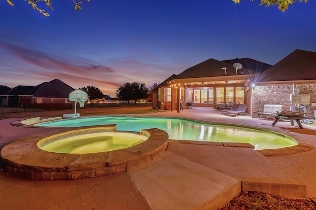 view of swimming pool featuring a pool with connected hot tub and a patio area