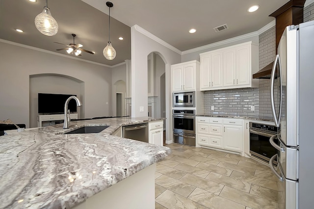 kitchen with white cabinets, sink, ceiling fan, appliances with stainless steel finishes, and light stone counters