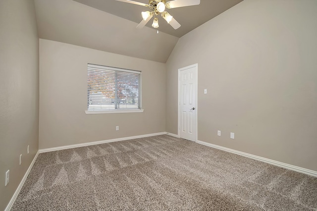 spare room with vaulted ceiling, carpet flooring, a ceiling fan, and baseboards