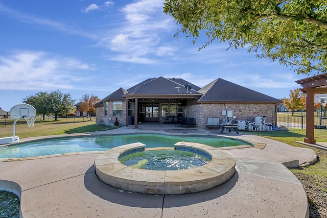 view of swimming pool with a yard, a pool with connected hot tub, fence, and a patio