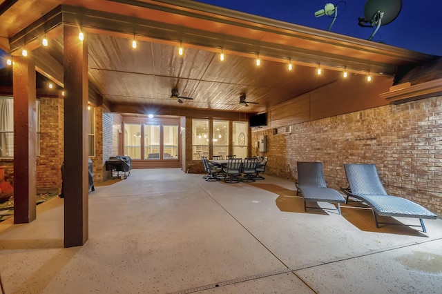 patio at night with outdoor dining space and a ceiling fan