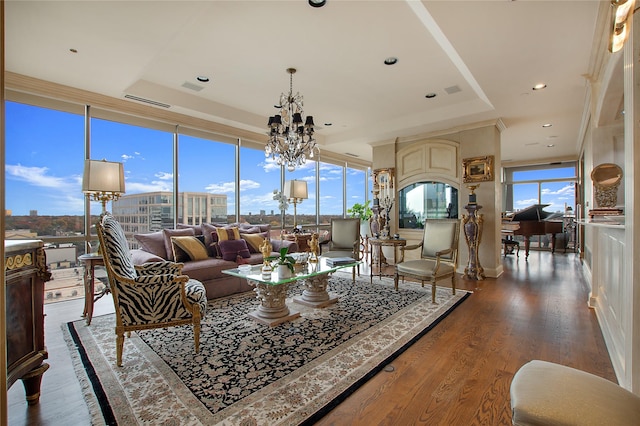 living room with a chandelier, hardwood / wood-style floors, and a raised ceiling