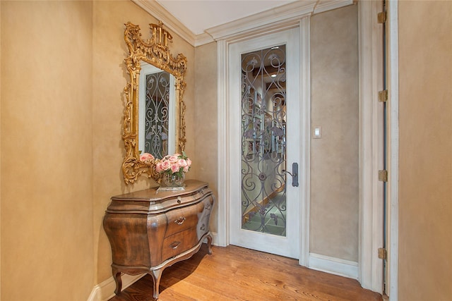 doorway to outside featuring crown molding and light hardwood / wood-style flooring