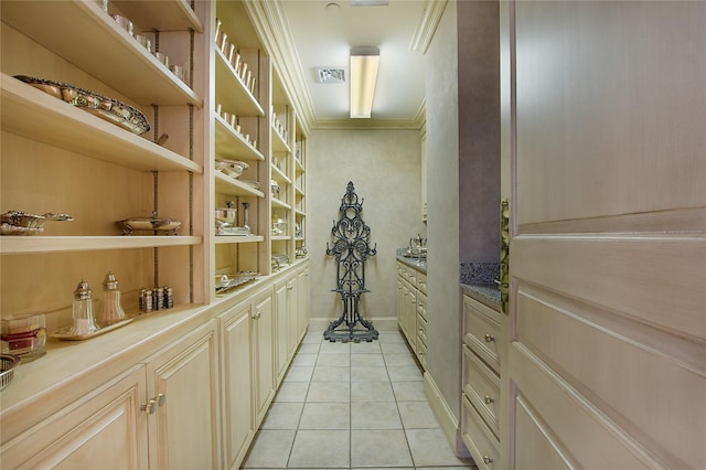 wine area featuring crown molding, built in features, and light tile patterned floors