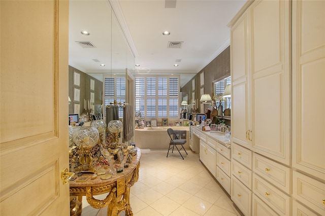 kitchen with cream cabinets, light tile patterned floors, ornamental molding, and sink