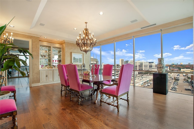 dining area featuring floor to ceiling windows, wood-type flooring, a chandelier, and a tray ceiling