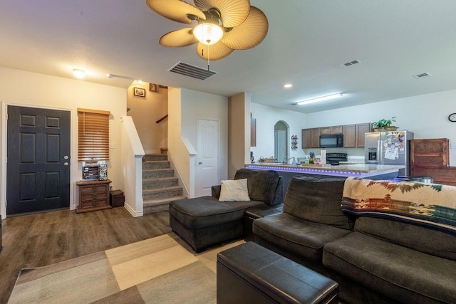 living room featuring light hardwood / wood-style floors and ceiling fan