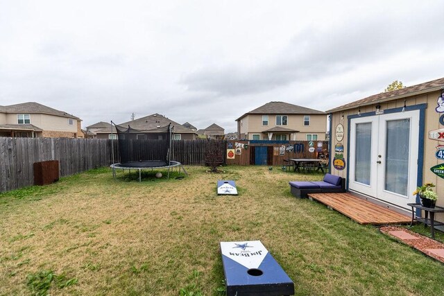 view of yard featuring french doors, a deck, and a trampoline