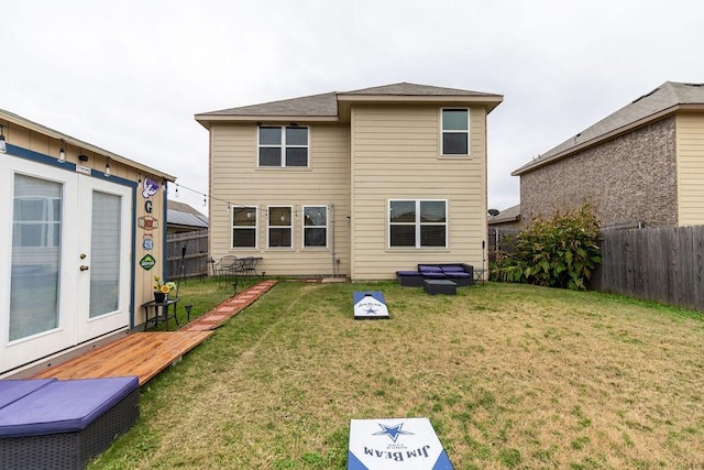 rear view of property with a deck, a yard, and french doors